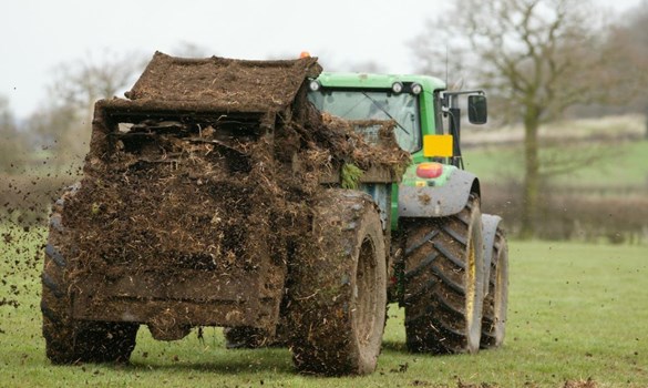 Tracker spreading muck across the field.